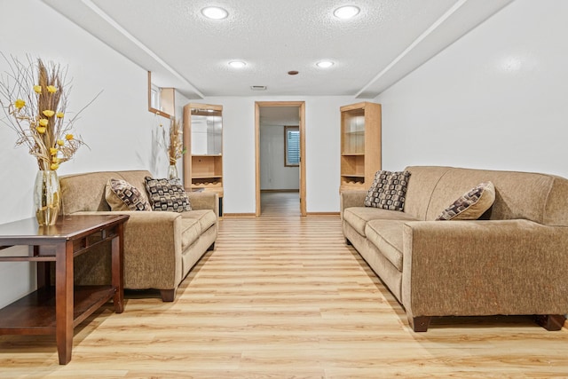 living room featuring a textured ceiling and light wood-type flooring