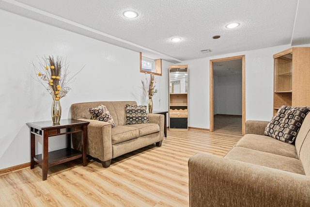 living room featuring wood-type flooring and a textured ceiling