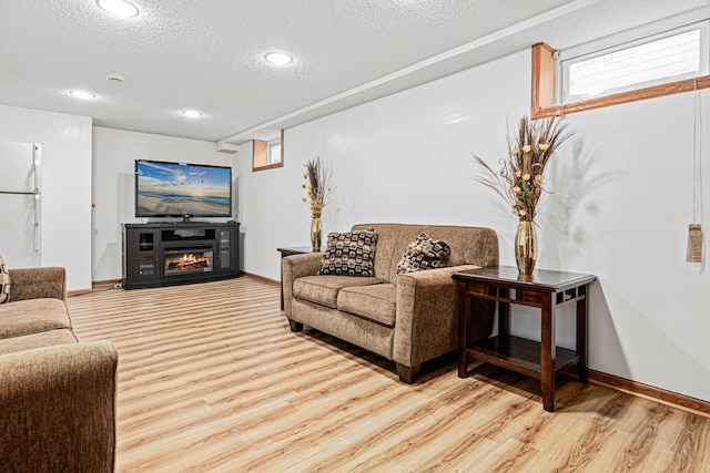 living room featuring light hardwood / wood-style flooring and a textured ceiling