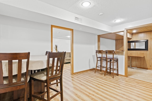 dining area featuring light hardwood / wood-style floors and a textured ceiling