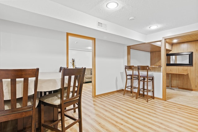 4425 2nd St NE, Columbia Heights, MN 55421 - dining room with wood finished floors, a bar, a textured ceiling, and baseboards