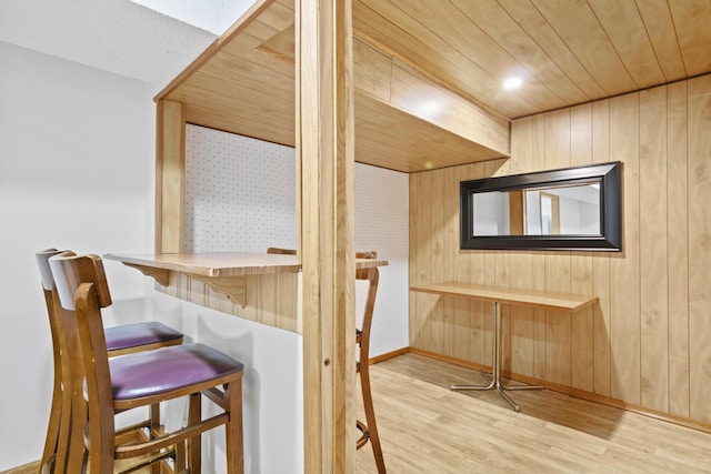 interior space featuring light hardwood / wood-style flooring, wooden walls, and wooden ceiling