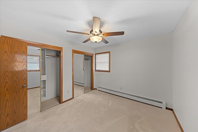 unfurnished bedroom with multiple windows, light carpet, and a baseboard radiator