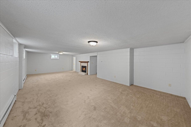 basement with light colored carpet, a textured ceiling, and a baseboard heating unit