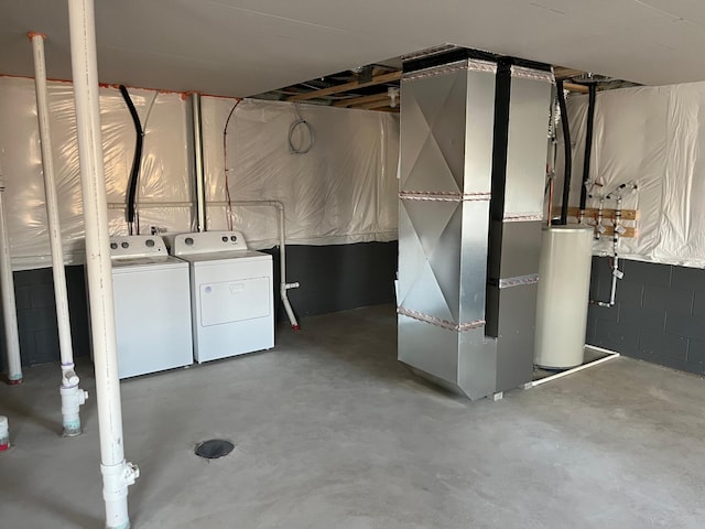 basement featuring washer and dryer, gas water heater, and heating unit