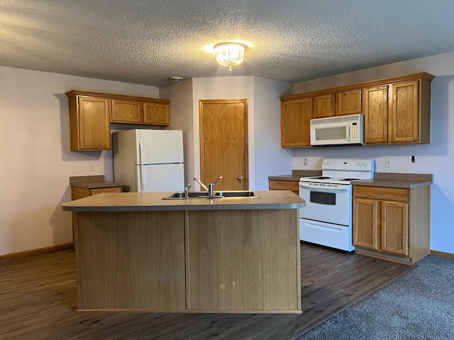 kitchen featuring a center island with sink, dark hardwood / wood-style flooring, sink, and white appliances