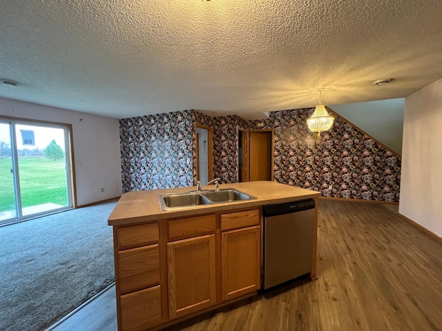 kitchen with dishwasher, hanging light fixtures, sink, and wood-type flooring