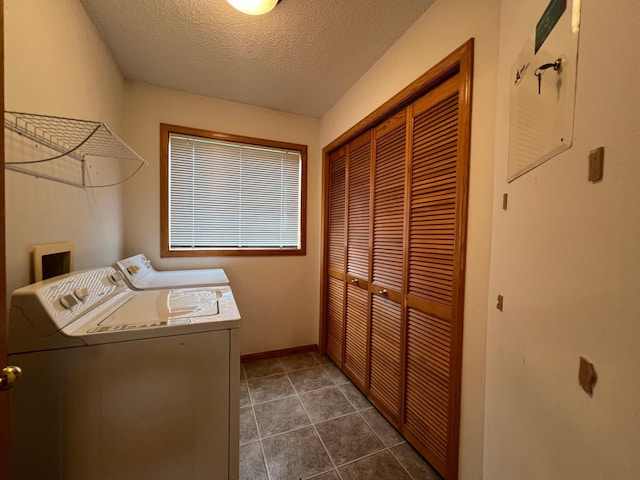 clothes washing area featuring dark tile patterned flooring, a textured ceiling, and separate washer and dryer