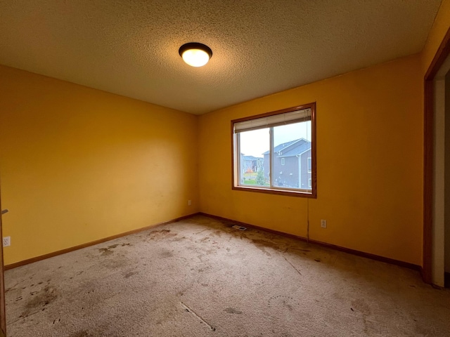 empty room with a textured ceiling and carpet floors