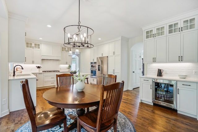 dining room with beverage cooler, dark wood-style flooring, arched walkways, and recessed lighting