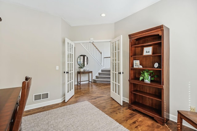 interior space with wood finished floors, visible vents, baseboards, stairs, and french doors