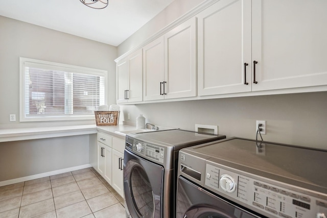 laundry room featuring cabinet space, light tile patterned floors, baseboards, washer and clothes dryer, and a sink