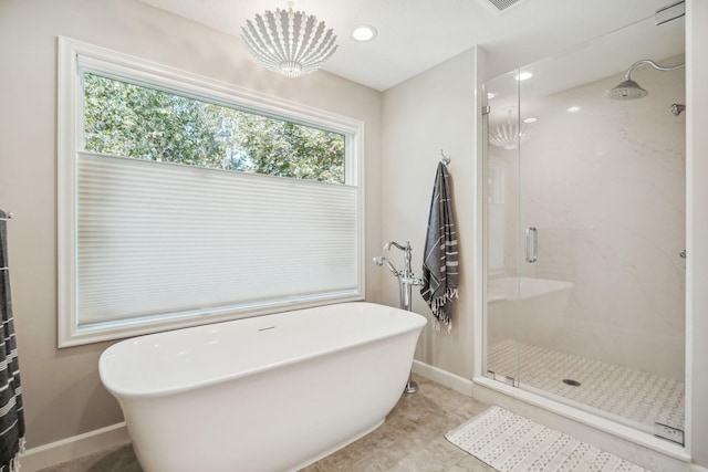 bathroom with a soaking tub, a shower stall, tile patterned flooring, and baseboards