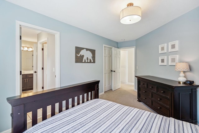 bedroom with light carpet, baseboards, and ensuite bathroom