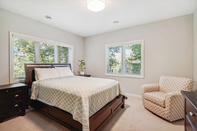 bedroom with light carpet and baseboards