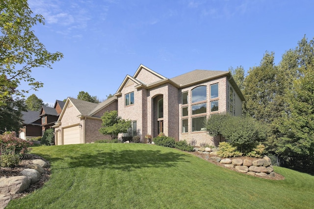 view of front facade featuring an attached garage, brick siding, and a front yard