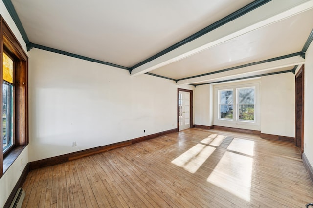 unfurnished room with baseboard heating, crown molding, beamed ceiling, and light wood-type flooring