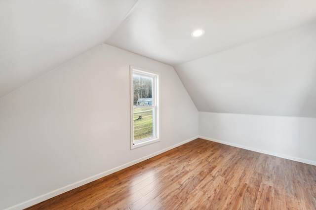 additional living space featuring hardwood / wood-style floors and lofted ceiling