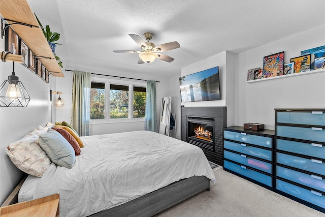 carpeted bedroom with ceiling fan and a textured ceiling