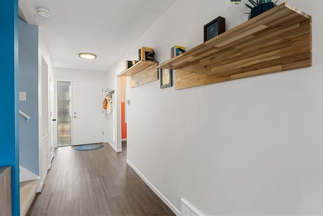 hall featuring dark hardwood / wood-style floors and a textured ceiling