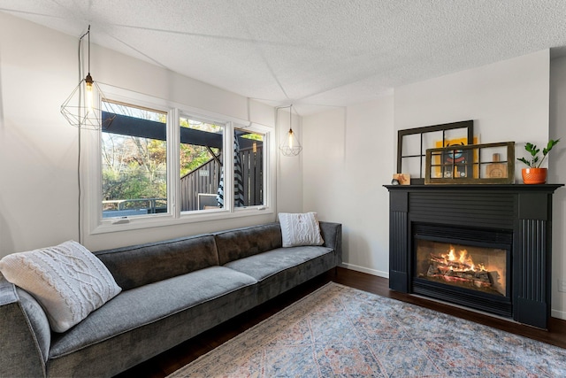 living room with dark wood-type flooring and a textured ceiling