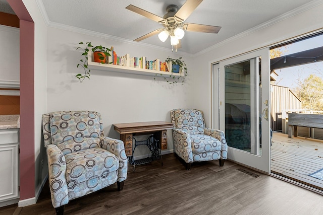 living area with ornamental molding, dark wood-type flooring, a textured ceiling, and ceiling fan