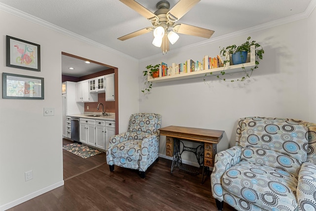 living area with crown molding, ceiling fan, dark hardwood / wood-style flooring, and sink