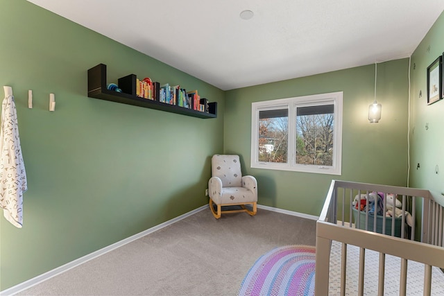 bedroom featuring a nursery area and carpet