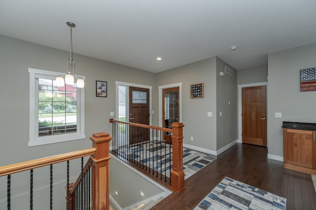 hallway with a notable chandelier and dark hardwood / wood-style floors