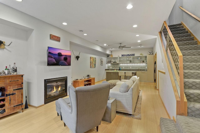 living room with light hardwood / wood-style flooring and ceiling fan