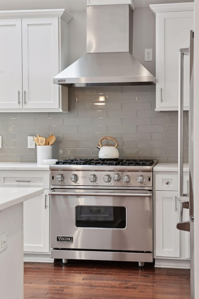 kitchen with white cabinetry, wall chimney range hood, and designer range