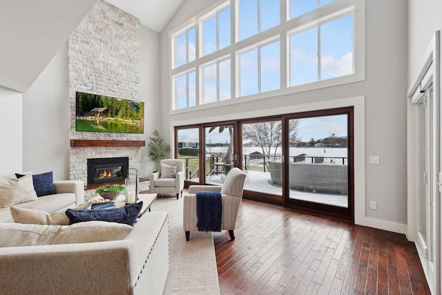 living room featuring a healthy amount of sunlight, dark hardwood / wood-style flooring, and a high ceiling