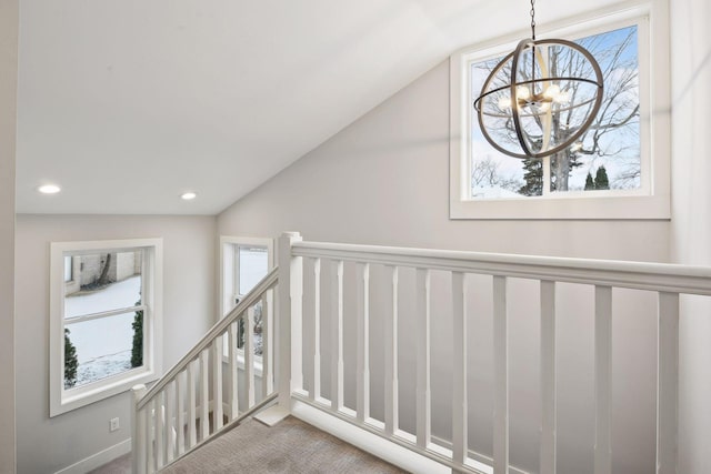 stairway featuring lofted ceiling, carpet flooring, and a wealth of natural light