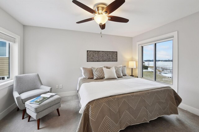 carpeted bedroom featuring ceiling fan and multiple windows