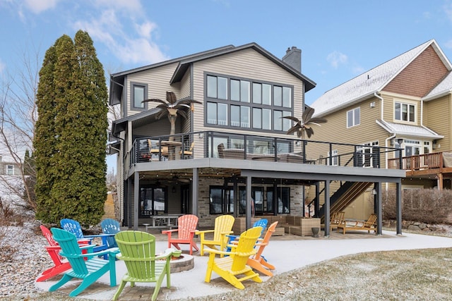 rear view of house featuring a patio, a wooden deck, and an outdoor fire pit