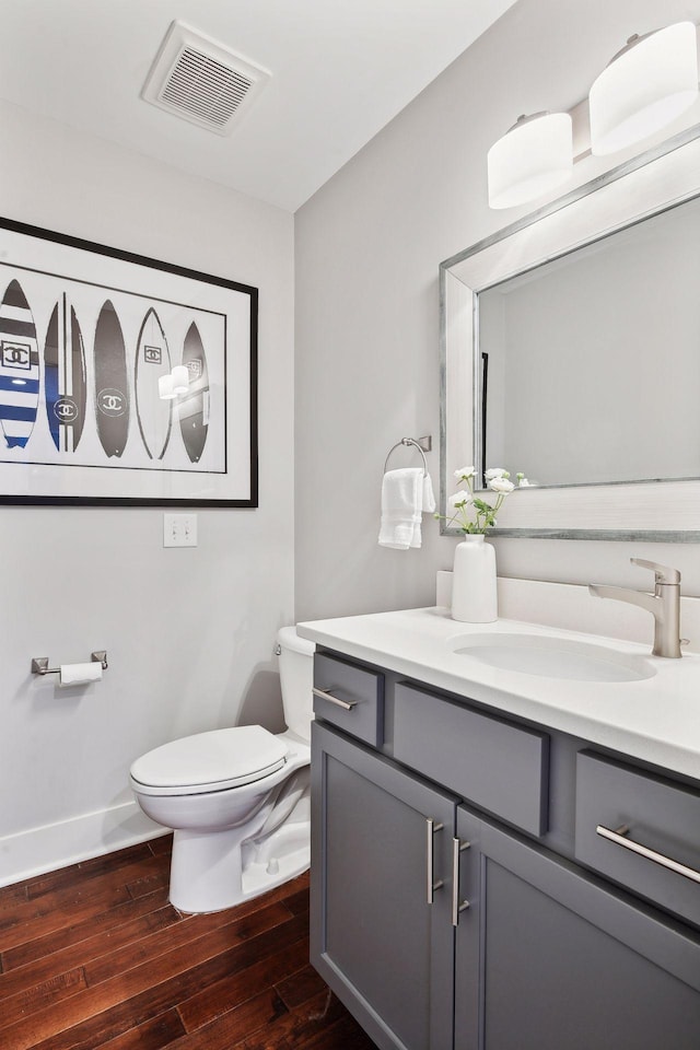 bathroom with vanity, toilet, and hardwood / wood-style floors