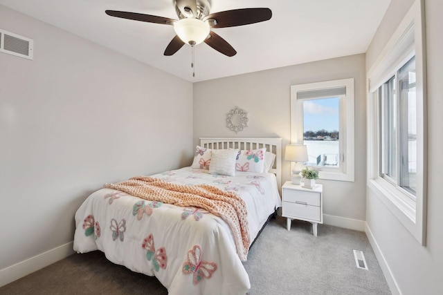 carpeted bedroom featuring multiple windows and ceiling fan