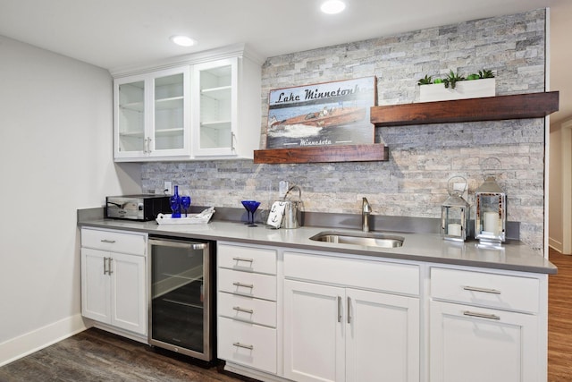 kitchen with wine cooler, white cabinetry, sink, and decorative backsplash