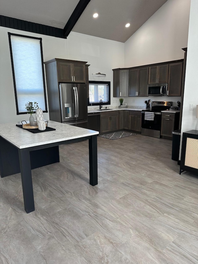kitchen featuring dark brown cabinetry, beamed ceiling, sink, appliances with stainless steel finishes, and high vaulted ceiling
