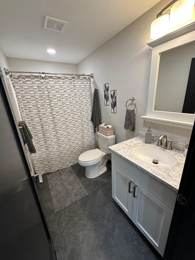 bathroom with curtained shower, vanity, tile patterned floors, and toilet