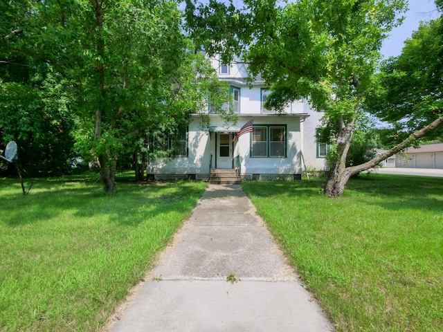 view of property hidden behind natural elements with a front lawn and stucco siding