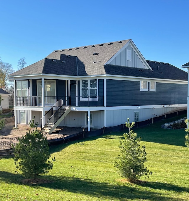 back of property with a sunroom and a lawn