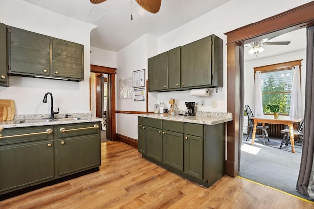 kitchen with ceiling fan, sink, light hardwood / wood-style flooring, and green cabinetry