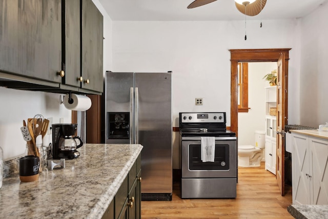 kitchen with ceiling fan, stainless steel appliances, dark brown cabinetry, light stone countertops, and light hardwood / wood-style floors