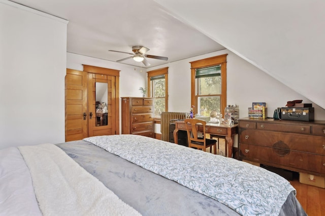 bedroom with ceiling fan, wood-type flooring, and vaulted ceiling