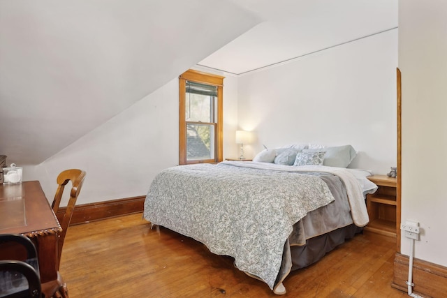 bedroom with hardwood / wood-style flooring and vaulted ceiling