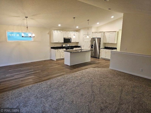 kitchen with white cabinets, appliances with stainless steel finishes, pendant lighting, and lofted ceiling