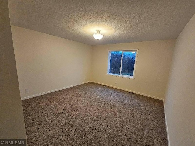 carpeted empty room with a textured ceiling