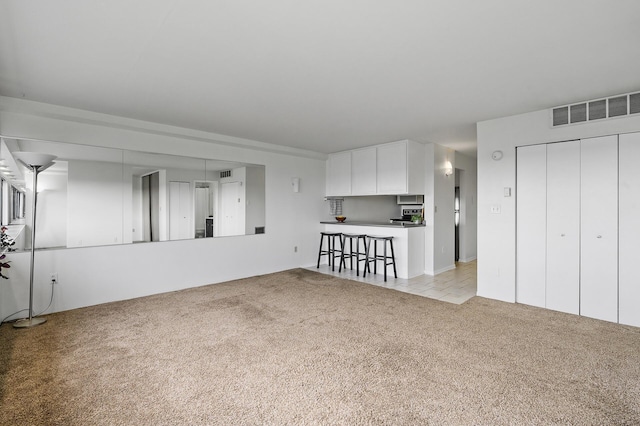 unfurnished living room featuring light colored carpet