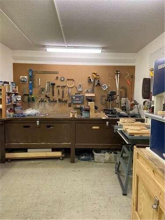 miscellaneous room featuring a workshop area and a textured ceiling